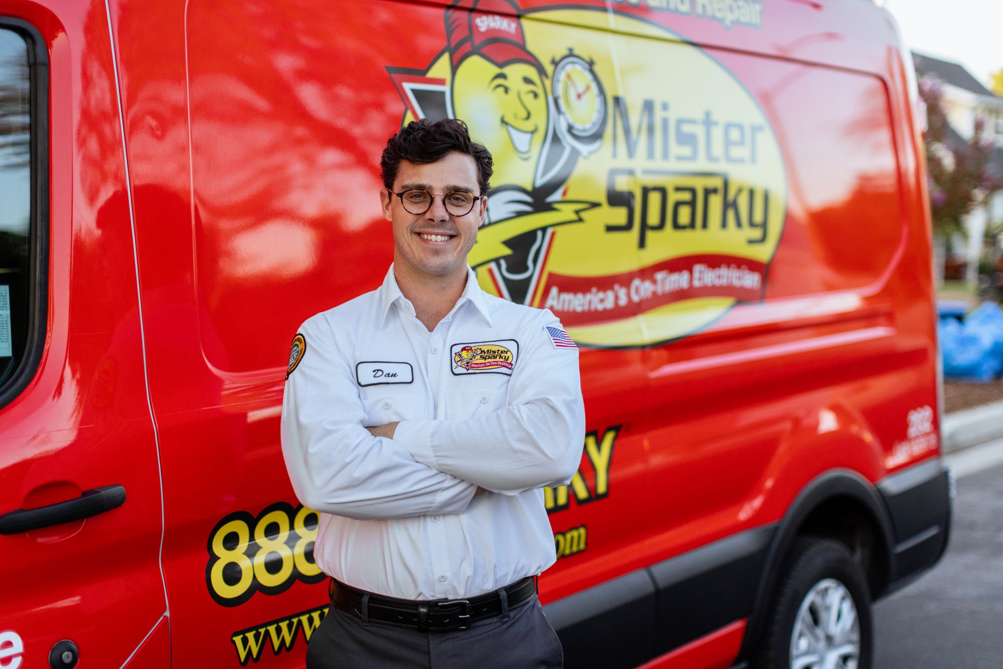 Mister Sparky electrical business franchise owner in front of a branded van.