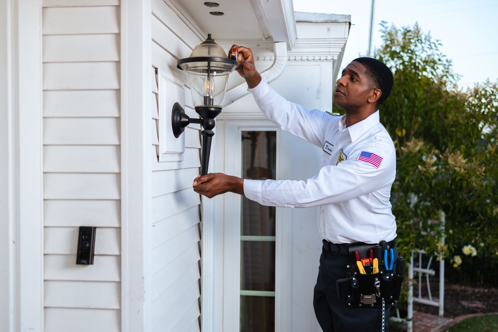 Mister Sparky electrician installing an outdoor light.